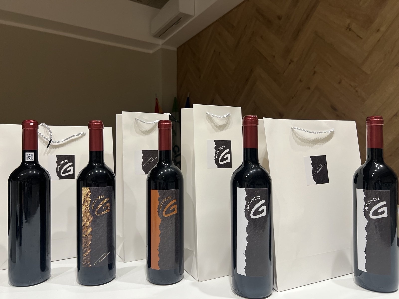 Premium Merlot and Cabernet bottles displayed with branded bags